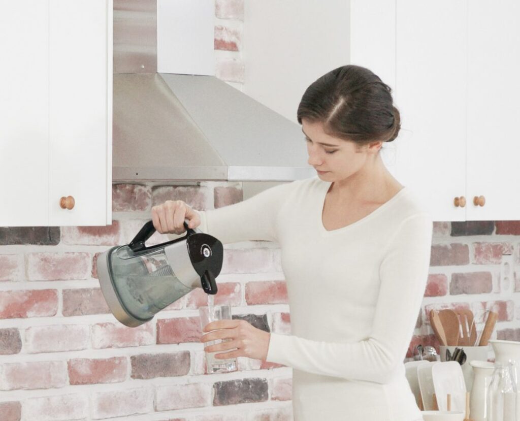 woman using Haptra hydrogen water generator to produce hydrogen rich drinking water
